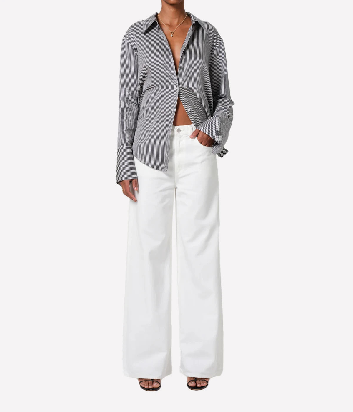 ALT text: Off-white classic straight jeans with high rise, styled with a tucked-in blouse and heels.