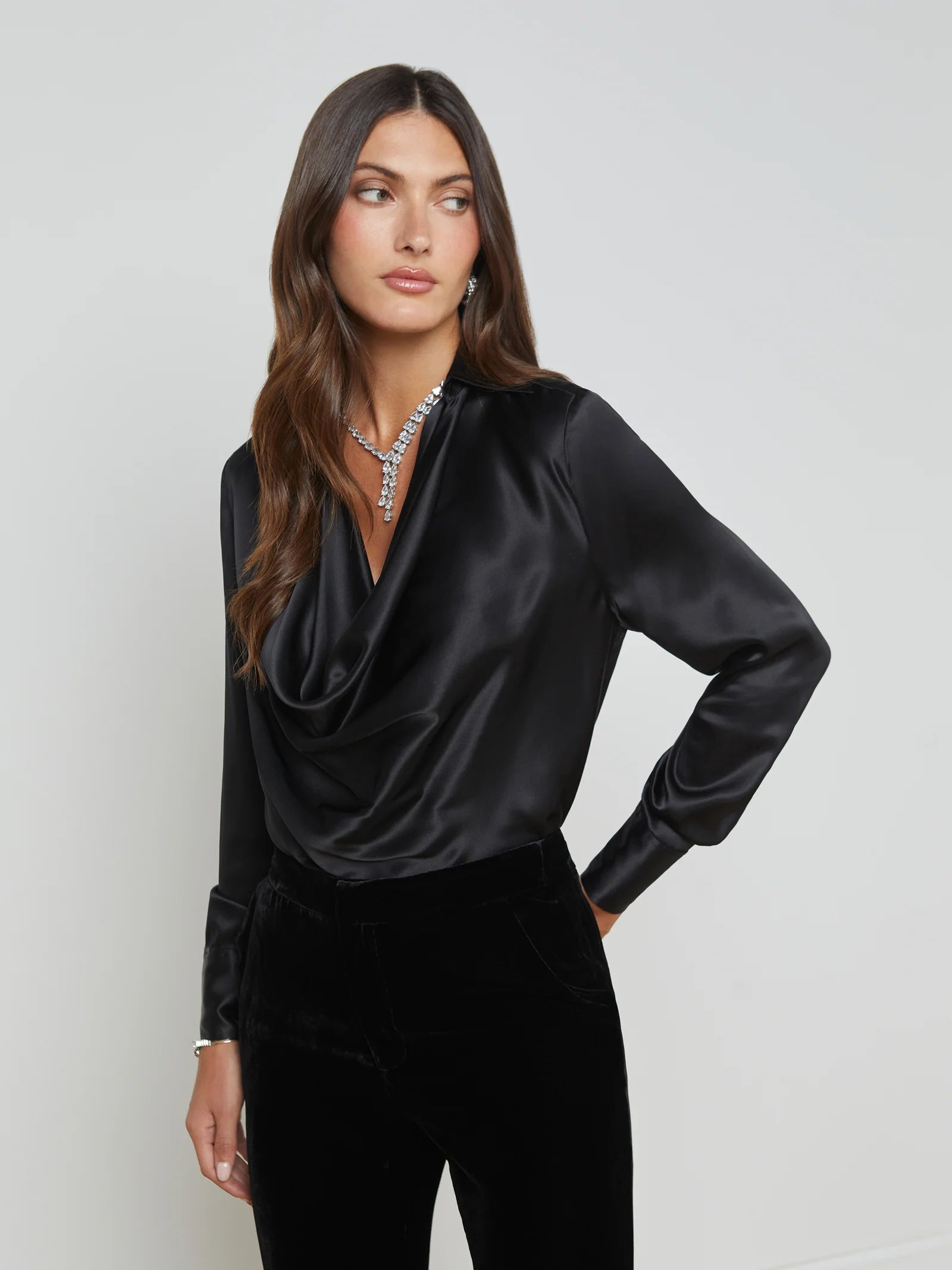 ALT text: Silk cowl neck blouse styled with a leather skirt and heels for a polished evening look.