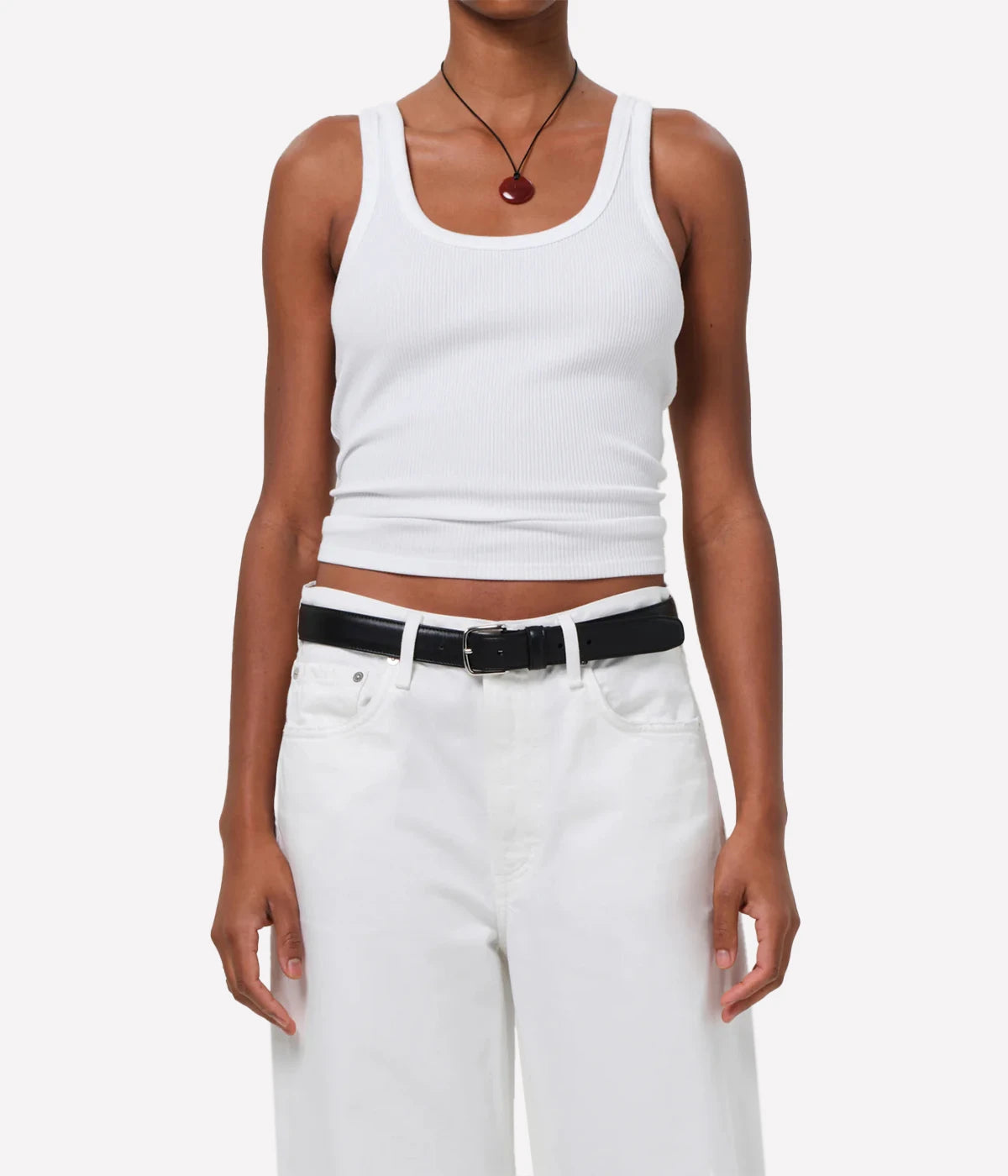 ALT text: White scoop neck ribbed tank top, styled with high-waisted jeans.