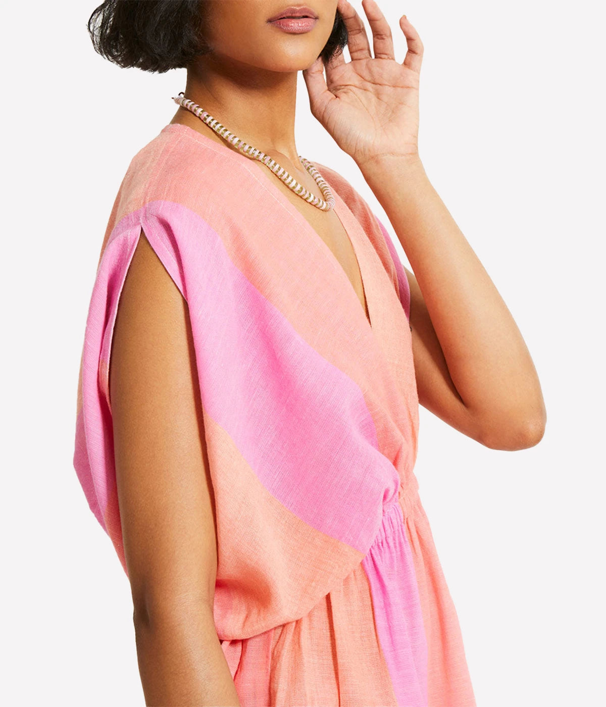 A gauzy short dress with dolman sleeves and an ombre colour block in pink, blush, and peach, styled with sandals for a relaxed resort-ready look.