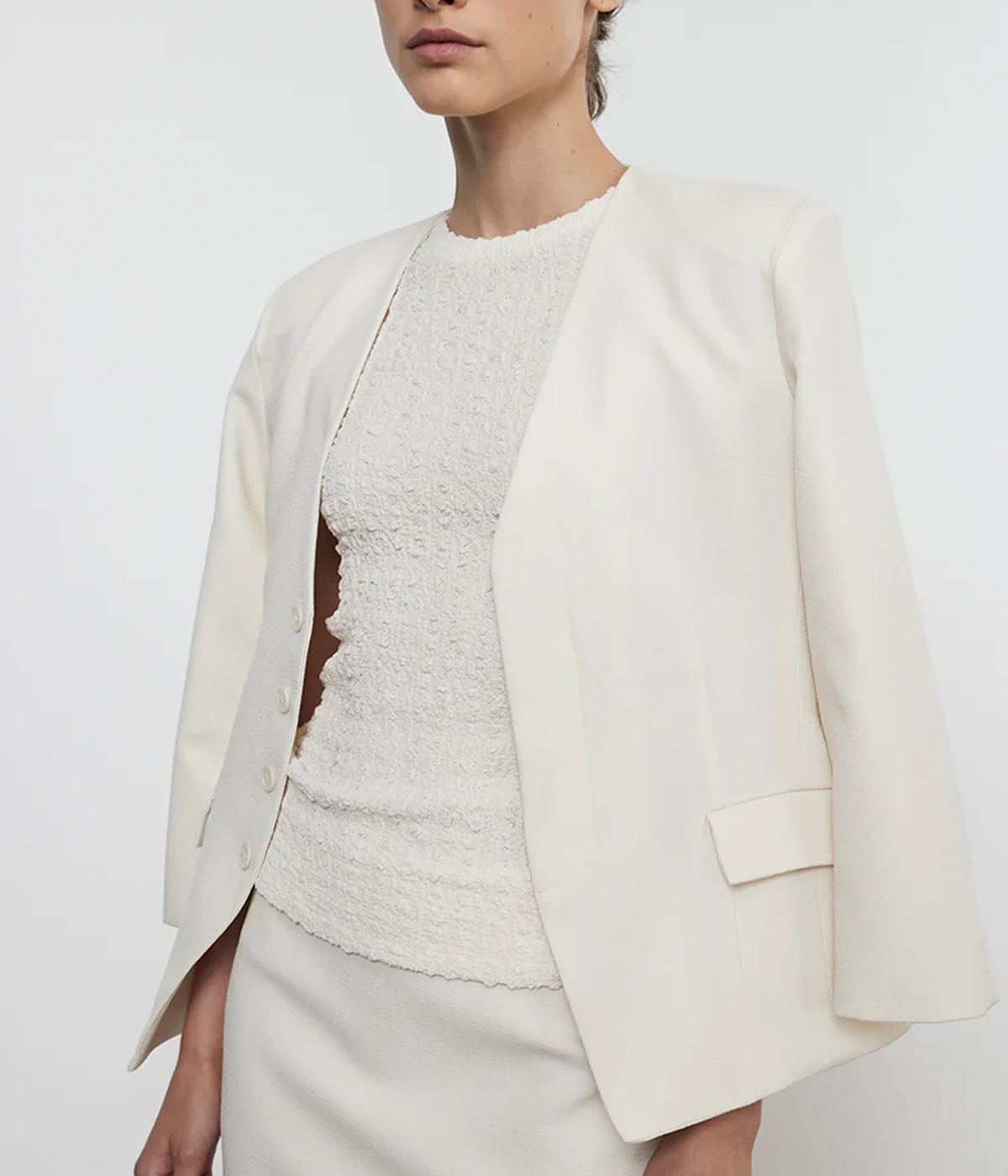 ALT text: Tailored cream crepe jacket with padded shoulders, concealed button placket, and smooth lining, styled for a polished, sophisticated look.