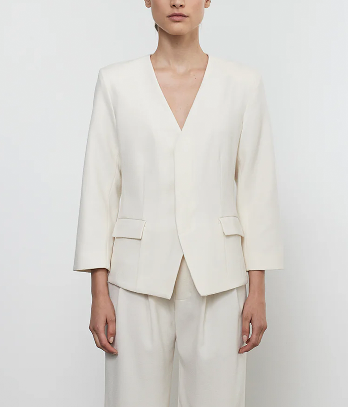 ALT text: Tailored cream crepe jacket with padded shoulders, concealed button placket, and smooth lining, styled for a polished, sophisticated look.