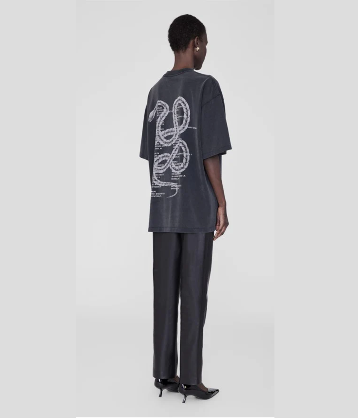 ALT Text for Product Image: A relaxed-fit graphic tee in washed charcoal with a twisted snake design, styled with high-waisted denim and ankle boots for an edgy, versatile look.