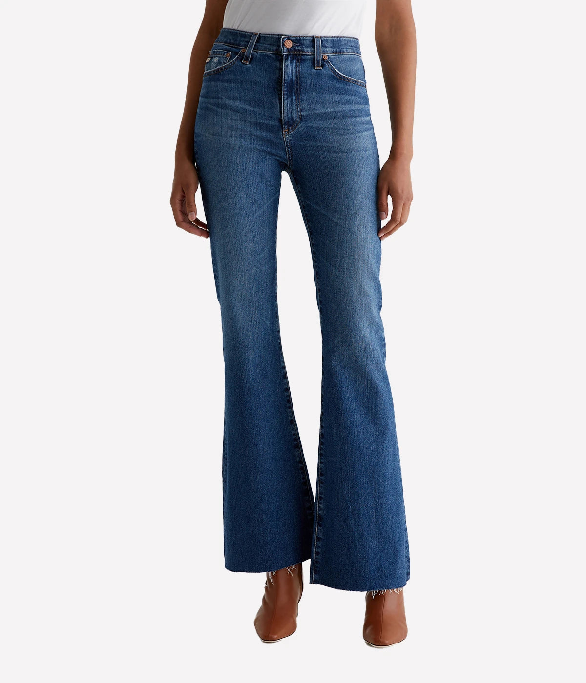 A pair of Madi high-rise flare jeans from AG in dark indigo wash with fading, whiskering, and raw hems. The jeans feature a high-rise waist and flare from the knee down, with a flattering fit through the hips.