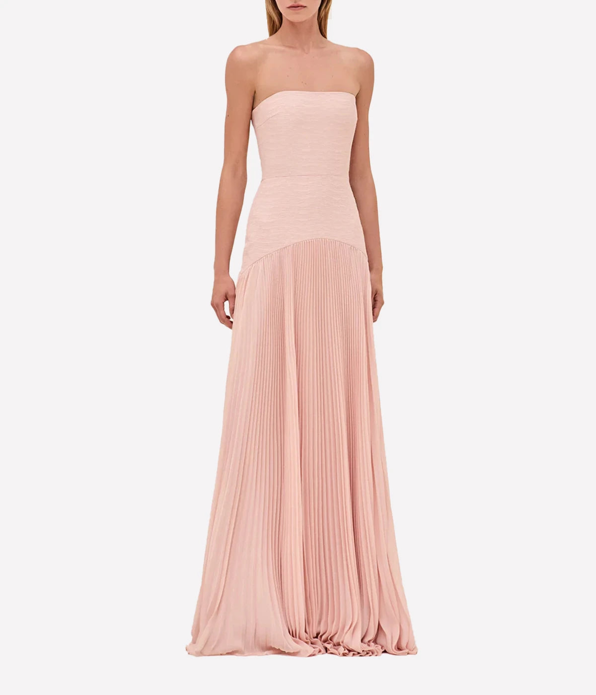 ALT text: Pink strapless gown with pleated skirt, styled with statement heels and jewellery.