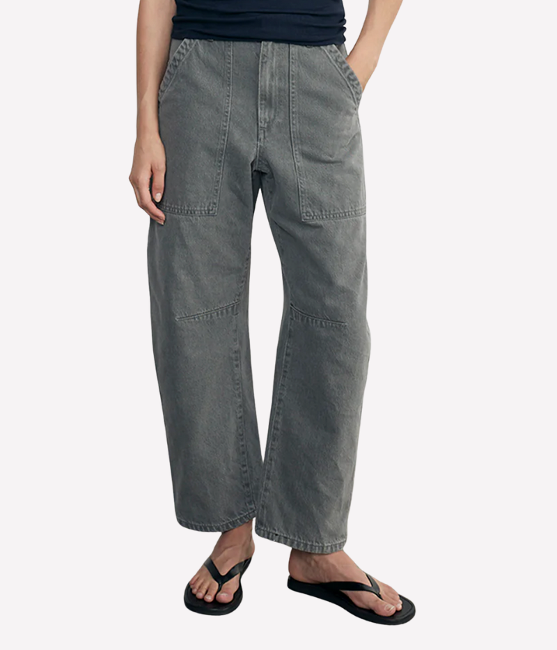 Cotton denim utility pants with a barrel-shaped silhouette, knee seam details, and front patch pockets, styled for a casual, laid-back look.